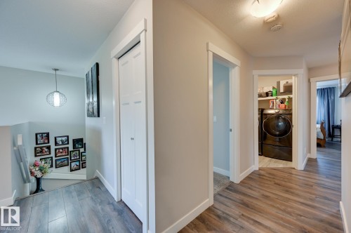 Upper-level landing featuring wood-finish flooring, light neutral wall tones, and white trim - 101 Hilldowns Drive, Spruce Grove, AB 