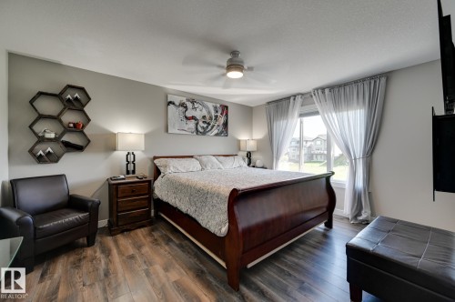 Spacious bedroom featuring wood-finish flooring and a ceiling fan - 101 Hilldowns Drive, Spruce Grove, AB 