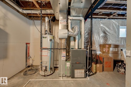 Basement utility area featuring a water heater, furnace, and exposed ceiling joists - 101 Hilldowns Drive, Spruce Grove, AB 