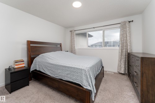 Carpeted bedroom with a horizontal window featuring drapes - 2522 152 Avenue Nw, Edmonton, AB - Indoor Photo Showing Bedroom