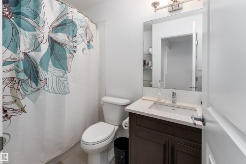 Full bathroom featuring a single vanity with a solid surface countertop, undermount sink, and chrome faucet - 2522 152 Avenue Nw, Edmonton, AB - Indoor Photo Showing Bathroom