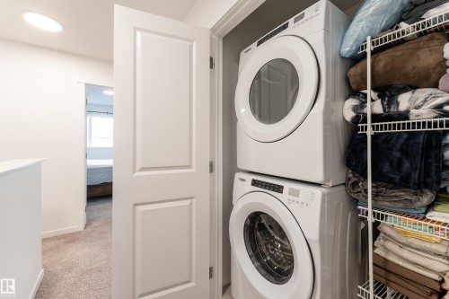 Dedicated laundry closet featuring a stackable washer and dryer unit - 2522 152 Avenue Nw, Edmonton, AB - Indoor Photo Showing Laundry Room