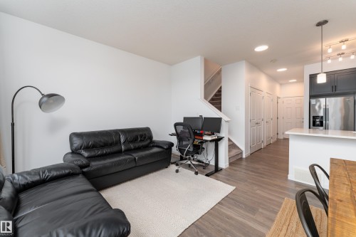 Open-concept living space featuring wood-finish laminate flooring and recessed lighting - 2522 152 Avenue Nw, Edmonton, AB - Indoor