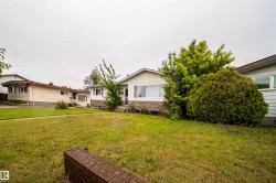 Manicured front yard with mature shrubbery and established trees - 