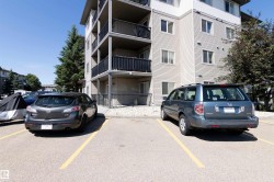 Multi-story apartment building exterior featuring horizontal siding and multiple balconies with black railings - 