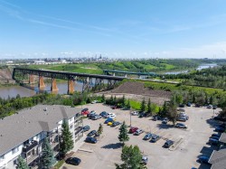 River valley scenery with a prominent bridge structure, multiple parking areas, and mature evergreen landscaping - 