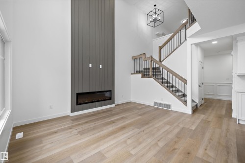 Soaring ceilings with a full-height accent wall featuring a linear electric fireplace - 915 Elderberry Landing Nw, Edmonton, AB - Indoor With Fireplace