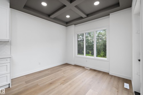 Room featuring light wood-finish flooring, a coffered ceiling with recessed lighting, and a large multi-pane window - 915 Elderberry Landing Nw, Edmonton, AB - Indoor Photo Showing Other Room