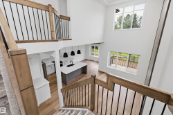 Two-story living area with hardwood-finish flooring, a contemporary kitchen island with a dark sink, and multiple large windows - 