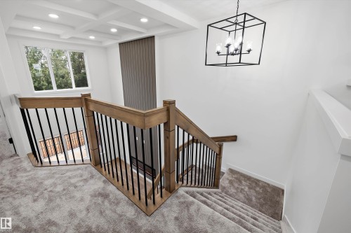 Staircase featuring wood railings with black balusters, carpeted stairs, and recessed lighting - 915 Elderberry Landing Nw, Edmonton, AB - Indoor Photo Showing Other Room