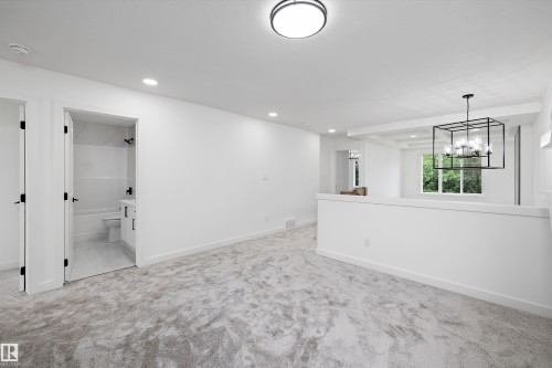 Spacious carpeted room featuring recessed lighting and a contemporary ceiling light fixture - 915 Elderberry Landing Nw, Edmonton, AB - Indoor Photo Showing Other Room