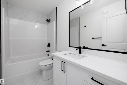 Contemporary bathroom featuring a white vanity with a quartz countertop, an undermount sink, and matte black fixtures - 915 Elderberry Landing Nw, Edmonton, AB - Indoor Photo Showing Bathroom