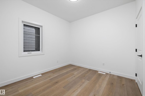 Room featuring light wood-finish flooring, white baseboards, and a white ceiling - 915 Elderberry Landing Nw, Edmonton, AB - Indoor Photo Showing Other Room