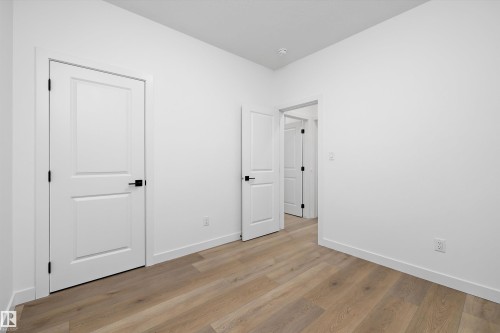 Room featuring light wood-finish flooring, white walls, and white trim - 915 Elderberry Landing Nw, Edmonton, AB - Indoor Photo Showing Other Room