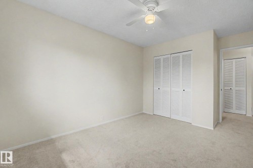Carpeted room featuring a ceiling fan with light fixture, louvered bi-fold closet doors, and light-toned wall finishes - 170 Westridge Rd, Edmonton, AB - Indoor