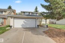 Two-story residence featuring a two-car garage with white panel door, light brick facade, and a covered entry with arched architectural details - 170 Westridge Rd, Edmonton, AB  - Outdoor 