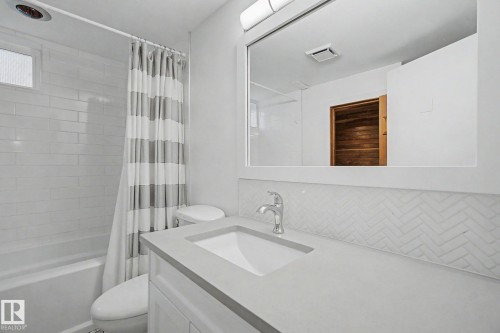 Bathroom featuring a white vanity with an integrated sink, polished chrome faucet, and light gray countertop - 170 Westridge Rd, Edmonton, AB - Indoor Photo Showing Bathroom