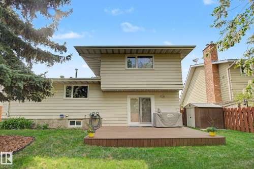 Expansive backyard featuring a composite deck, manicured lawn, mature trees, and a privacy fence - 170 Westridge Rd, Edmonton, AB - Outdoor With Deck Patio Veranda