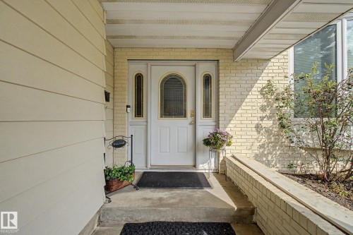 Front entryway featuring a white arch-top door with sidelight windows, light-colored brick facade, and horizontal siding - 170 Westridge Rd, Edmonton, AB - Outdoor With Exterior