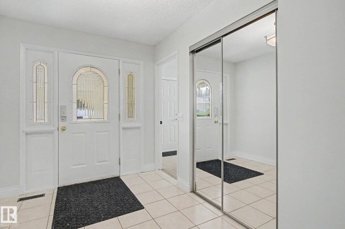 Entryway featuring a decorative main door with glass inserts and side lites, complemented by light-toned tile flooring - 170 Westridge Rd, Edmonton, AB - Indoor Photo Showing Other Room