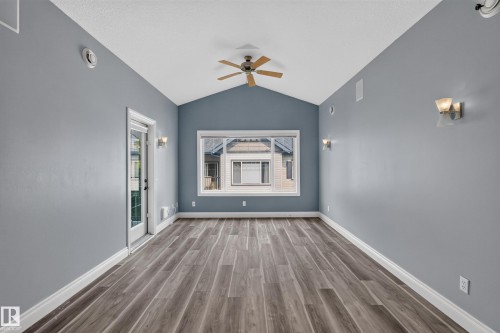 Vaulted ceiling room featuring wood-finish flooring, a ceiling fan, and a transom window - 18 2565 Hanna Crescent, Edmonton, AB 