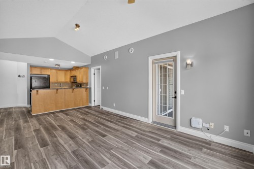 Spacious living area featuring wood-finish flooring, vaulted ceilings, and a neutral color palette - 18 2565 Hanna Crescent, Edmonton, AB 