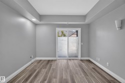 Room featuring wood-finish flooring, recessed lighting, and a sliding glass door with frosted panels - 