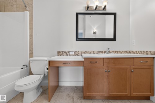 Bathroom featuring a full vanity with light wood-finish cabinetry, a white countertop, and an integrated sink - 18 2565 Hanna Crescent, Edmonton, AB 