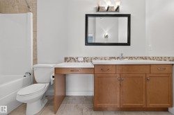 Bathroom featuring a full vanity with light wood-finish cabinetry, a white countertop, and an integrated sink - 