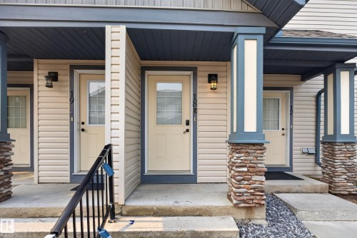 Exterior entryways featuring stone-clad columns and overhead lighting fixtures - 18 2565 Hanna Crescent, Edmonton, AB 