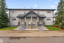 Cream-colored siding building featuring a dark gray roof - 