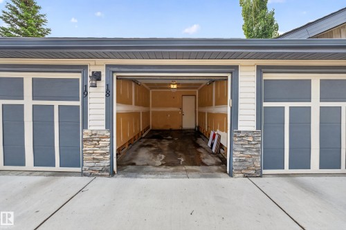 Attached garage featuring a concrete driveway and stone accents - 18 2565 Hanna Crescent, Edmonton, AB 