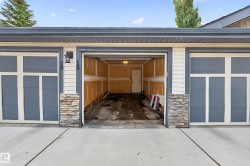 Attached garage featuring a concrete driveway and stone accents - 