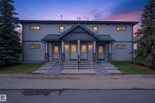 Two-story multi-unit structure featuring vertical siding and stone accents - 18 2565 Hanna Crescent, Edmonton, AB 