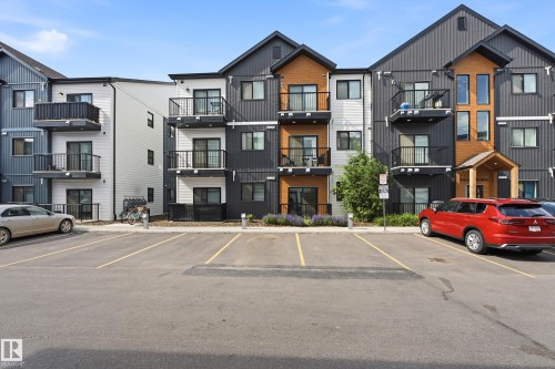 Modern multi-story building featuring dark vertical siding and light horizontal siding with wood-tone accents - 106 856 Secord Boulevard Nw, Edmonton, AB 
