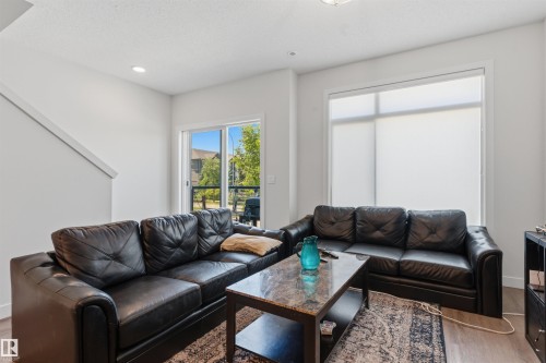 Bright living area featuring white walls, recessed lighting, and wood-finish flooring - 170 804 Welsh Drive, Edmonton, AB 