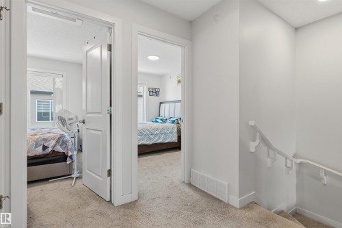 Neutral-toned carpeted hallway with white interior doors and trim - 170 804 Welsh Drive, Edmonton, AB 