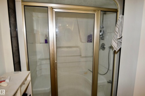 Shower enclosure with framed glass doors, integrated shelving, a shower wand and a steam shower - 7923 94 Avenue Nw, Edmonton, AB 