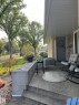 Front porch featuring a textured concrete surface and stairs, complemented by a stone accent wall - 7923 94 Avenue Nw, Edmonton, AB 