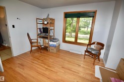Hardwood flooring featured in a room with white walls and a large window - 