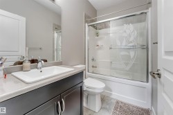 Full bathroom featuring a dark wood-finish vanity with a rectangular basin sink and a chrome faucet - 