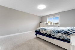 Bedroom featuring light gray wall paint, white trim, light-colored carpeting, a white ceiling, and a flush mount light fixture - 