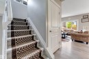 Carpeted staircase with patterned runner and white balusters - 5930 19A Avenue, Edmonton, AB 