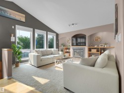 Vaulted ceiling living area featuring a built-in fireplace, integrated shelving, large windows, and neutral carpeting - 