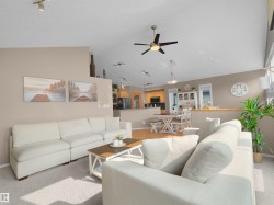 Vaulted ceiling with an installed ceiling fan, track lighting, and a neutral color palette - 