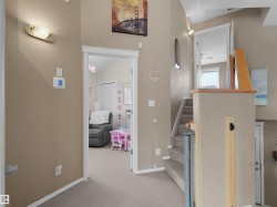 Upper-level landing featuring carpeted flooring and walls painted in a neutral tone - 