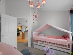 Interior room featuring a white panel door, light gray wall paint, and a decorative ceiling light fixture - 