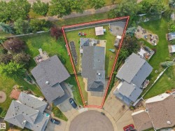 Aerial view of a residential property featuring a large backyard with mature trees - 
