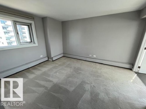 Carpeted room featuring a large window with white framing - 1101 10011 123 Street, Edmonton, AB 