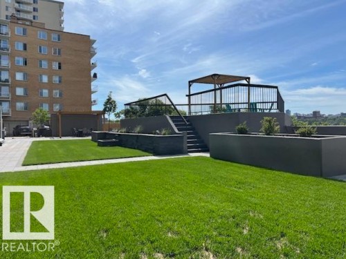 Manicured lawn area with raised planters and a concrete patio - 1101 10011 123 Street, Edmonton, AB 